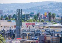 Trump-Backed Deal Dumps Water South Border crossing booths at Mexico entry point with cityscape in background