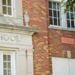 Old brick school building facade with windows and doorway