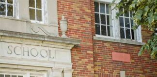 Old brick school building facade with windows and doorway