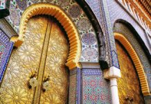 Arab World Jolt: Woman PM, Monarch Rules ornate golden doors with colorful mosaic arches