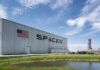 SpaceX hangar beside launch pad under blue sky