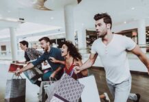 Group of friends running in a mall with shopping bags