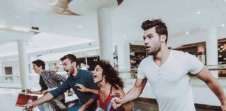 Group of friends running in a mall with shopping bags