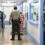 Navy Chief Nabbed In Child Predator Sting Corrections officers escort an inmate in a jail hallway