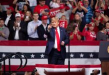 Trump Blitz Hits Nebraska – What’s Brewing? Donald Trump points from a rally stage; Rudi Koertzen and Bear Pascoe are in the crowd