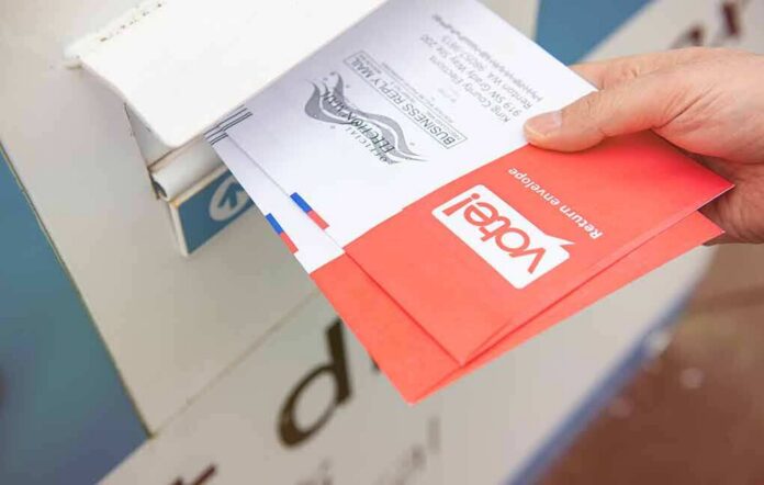 Hand dropping mail-in ballots into a drop box