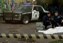 Shocking Video: 13 Stabs, Blade Lodged Crime scene with police car and two investigators by a covered body