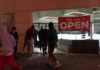 Milan Meltdown Triggers Army Patrols People outside a storefront with broken glass at night