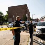 Homecoming Mayhem Shocks Georgia Town Police officers secure an urban street with yellow tape near patrol cars