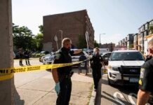 Homecoming Mayhem Shocks Georgia Town Police officers secure an urban street with yellow tape near patrol cars