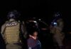 Counterterror Bombshell: Nigel Farage In The Crosshairs Police officers detain a handcuffed person at night