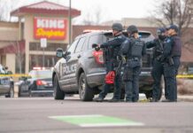 Deadly Hit-And-Run Near Campus Police officers gather beside a patrol SUV at a taped-off scene