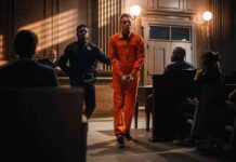 Outrage Builds As Parole Door Opens Defendant in orange jumpsuit escorted by officer in courtroom