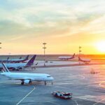 Airplanes on airport tarmac at sunset