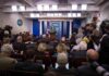 Record-Short Tenure Rattles West Wing Press secretary at podium addressing reporters in briefing room
